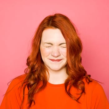 Woman with red hair on pink background