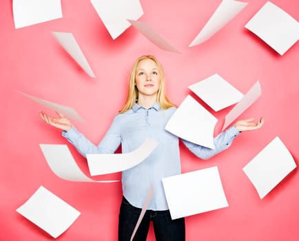 Businesswoman with flying papers on pink background
