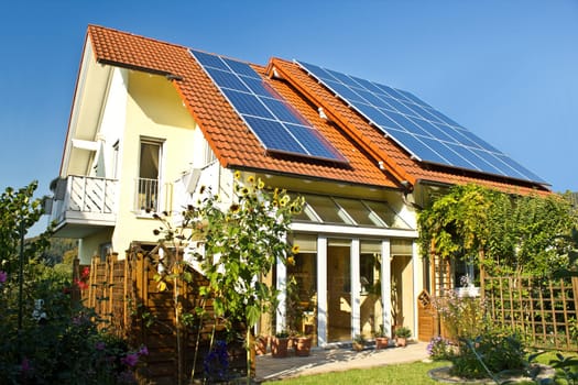 House with garden and solar panels on the roof
