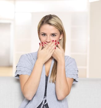 Young woman holding hands in front of her mouth