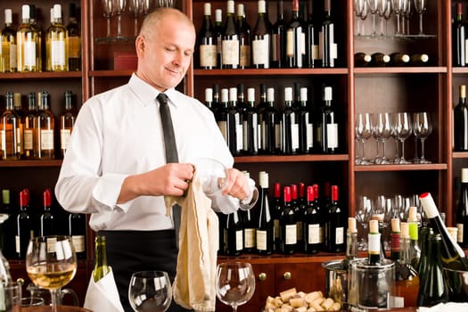 At the bar - waiter clean glass with dish clove restaurant