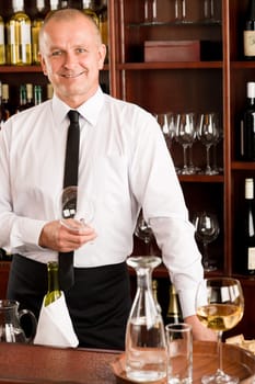 At the bar - waiter hold bottle white wine in restaurant