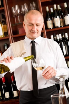 Wine bar happy waiter pour white wine in glass restaurant