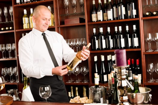 At the bar - waiter hold bottle white wine in restaurant