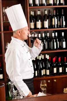 Chef cook smell glass of red wine in restaurant bar