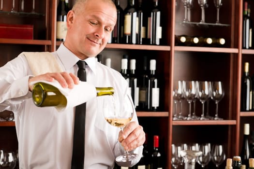 Wine bar happy waiter pour white wine in glass restaurant