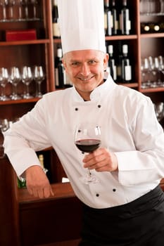 Chef cook hold glass of red wine in restaurant bar