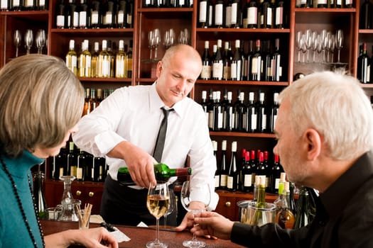Wine bar senior couple enjoy drink professional barman pour glass