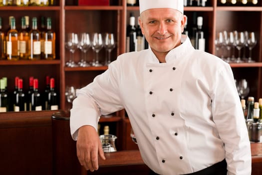 Chef cook confident professional posing in restaurant leaning over counter