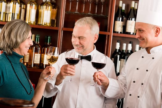 Restaurant manager posing with chef cook and waiter wine bar