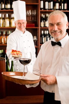 Chef cook with tapas waiter serve on tray in restaurant