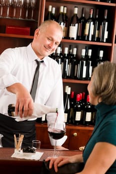 Wine bar professional waiter serve glass senior woman smiling