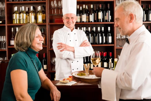 Restaurant manager smiling with staff at wine bar