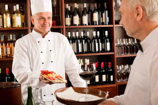 Chef cook with tapas waiter serve on tray in restaurant
