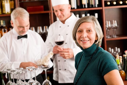 Restaurant manager smiling with staff at wine bar