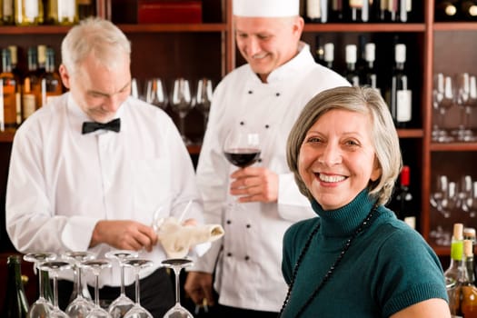Restaurant manager smiling with staff at wine bar