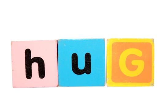 assorted childrens toy letter building blocks against a white background that spell hug with clipping path