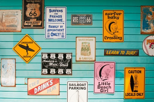 LONG BAY, WILLIKIES - AUGUST 20 2011: colorful antique signs on a blue wooden wall, surfing house on August 20, 2011 in Long Bay, ANTIGUA