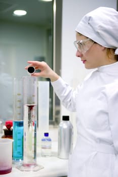 Chemical research laboratory, woman working, glass cylinder vase