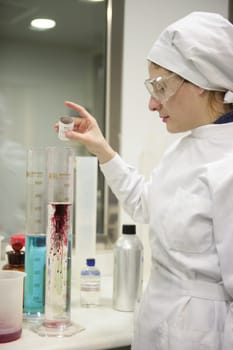 Chemical research laboratory, woman working, glass cylinder vase