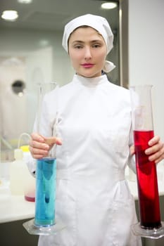 Chemical research laboratory, woman working, glass cylinder vase