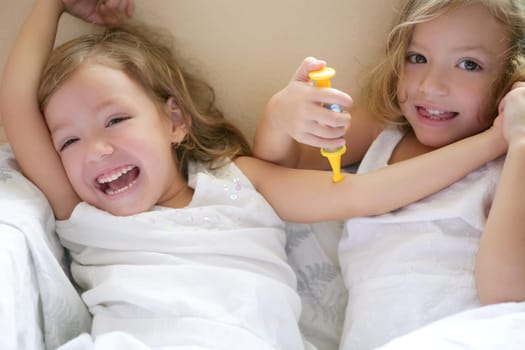 Two little twin sisters playing to be doctors with syringe