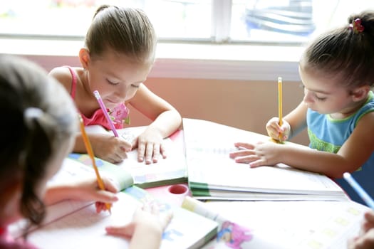 Beautiful little girls doing school homework at home