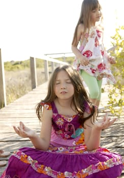 Hippy purple dress teen girl relaxed outdoors, sitting over the park wood