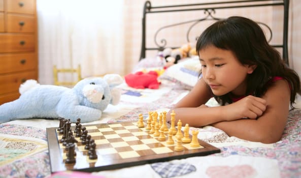 asian little girl playing home chess with teddy blue rabbit in her bedroom