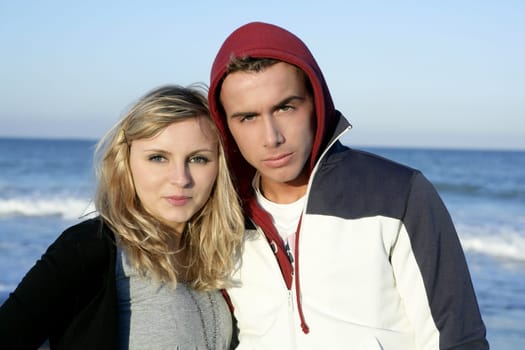 Happy beautiful young couple posing on the blue beach