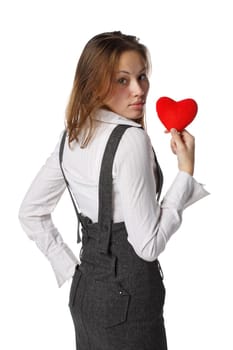 The beautiful girl holds in hands a red heart on a white background.