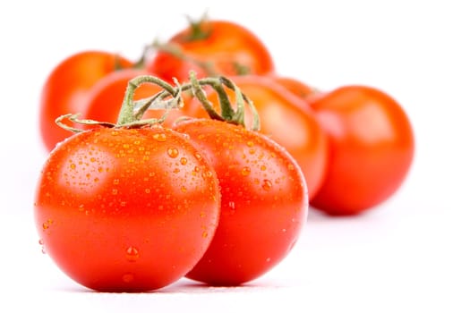 Fresh appetizing tomatoes with water drops on a white background