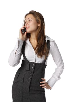 The young woman talks by a mobile phone on a white background.