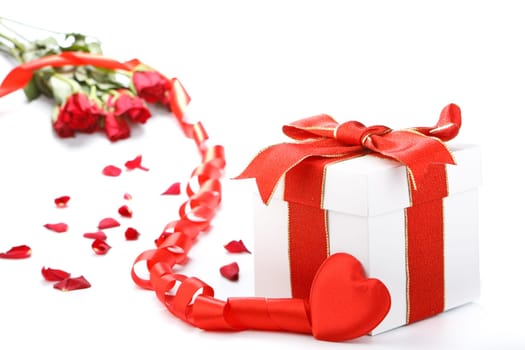 Gift box with red ribbon and flower on a white background