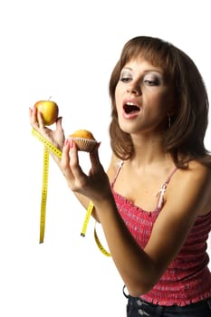 Young beautiful girl with apple and cake in her hands on a white background. Healthy food concept