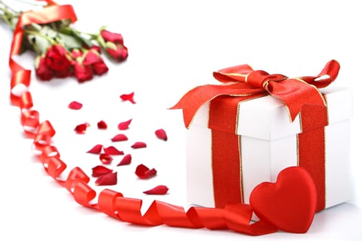 Gift box with red ribbon and flower on a white background