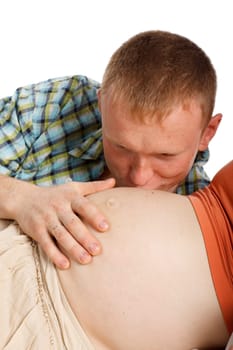 The happy father kisses a stomach of the pregnant wife