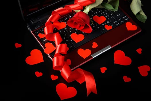Modern notebook and rose on a black background