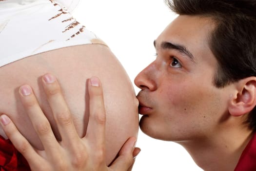 The happy father kisses a stomach of the pregnant wife