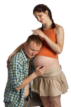 Young father listening heartbeat of his future child on a white background