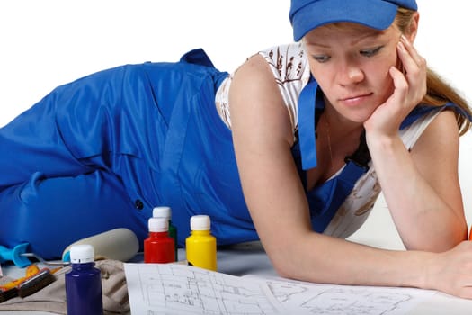 The pregnant woman dressed in working overalls, chooses colour for a children&#039 s room.