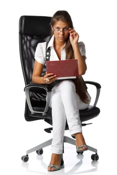 The attractive young woman with the laptop sits in an armchair on a white background.