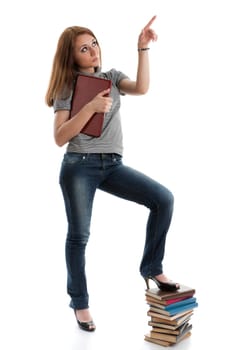 The attractive student stands with the laptop and books on a white background.