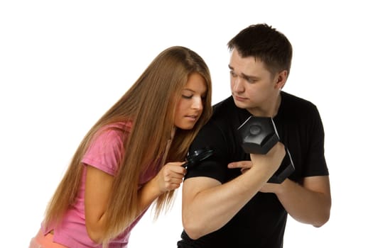 The beautiful girl considers a biceps of the young man by means of a magnifier.
