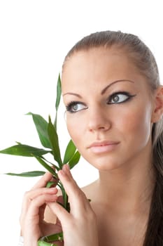The attractive girl with a bamboo branch on a white background