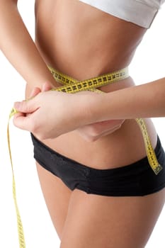 The beautiful girl measures a waist on a white background. Healthy lifestyles concept.
