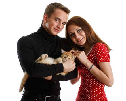 The happy young couple with a small amusing kitten on a white background.