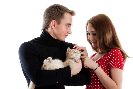 The happy young couple with a small amusing kitten on a white background.