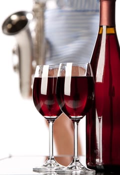 The wine bottle, two glasses and the sexual girl with a saxophone.