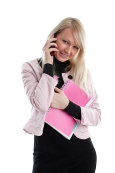 The beautiful girl stand with writing-books and mobile phone on a white background. The student.